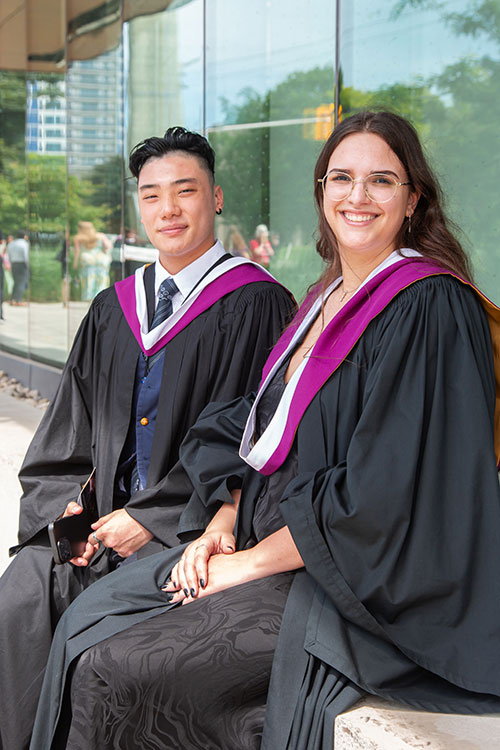 Arts grads sitting outside