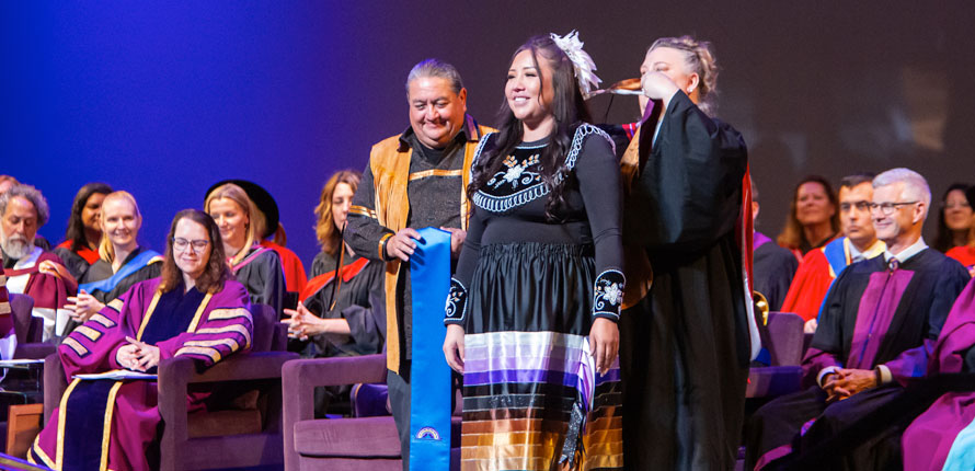 Student getting hooded with Indigenous stole