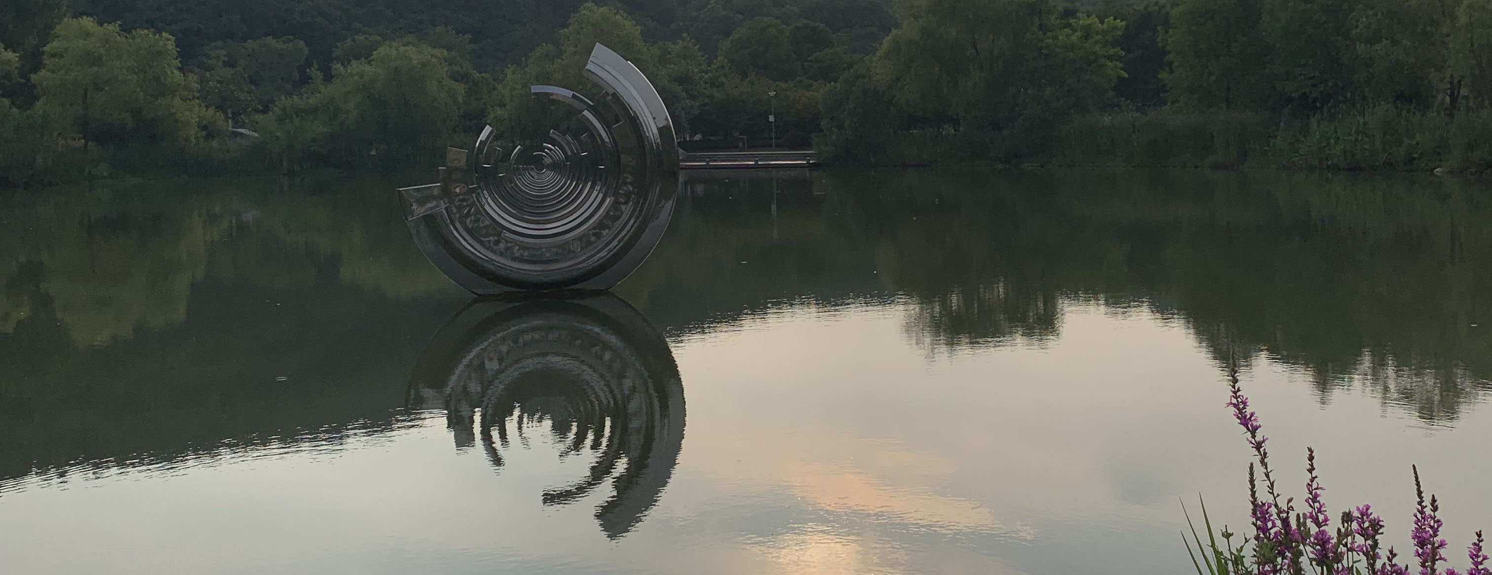 reflection of a round sculpture in water