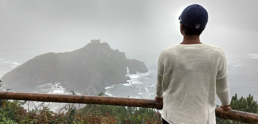 Student looking over ocean and cliffs