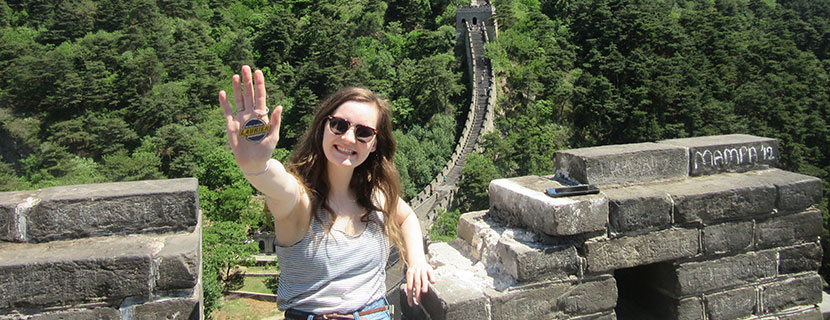 student holding Laurier keychain at the great wall of China