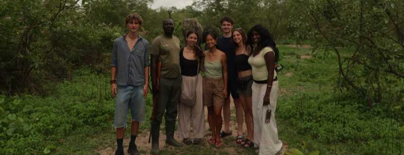 Laurier students in Ghana on a safari, they are posing in front of an elephant.