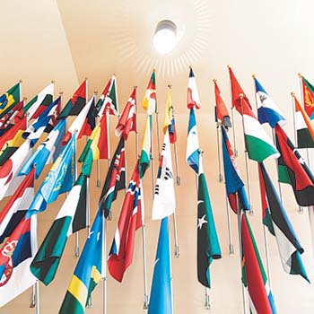 Flags from different countries hanging along a wall
