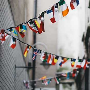 Spotlight story image pertaining to Flags of different countries hang along a rope