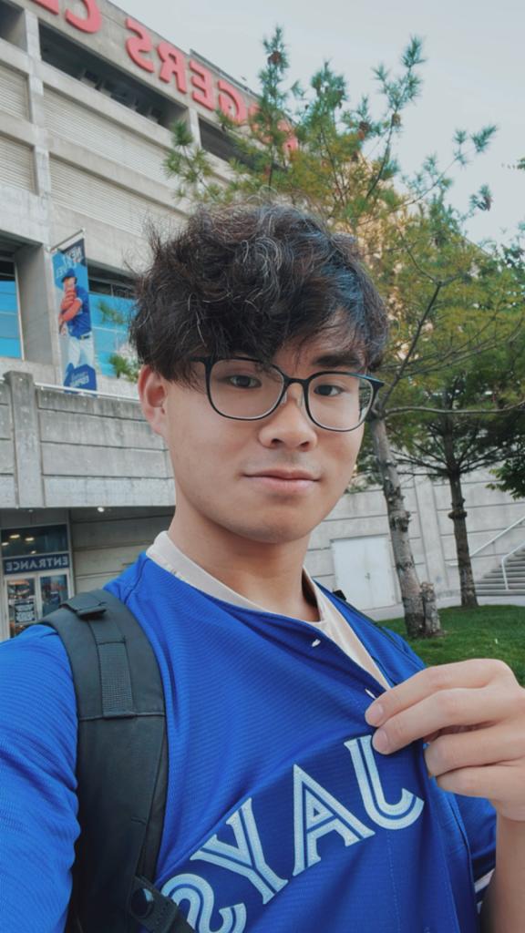 James Fong wearing a Blue Jays jersey in front of the Rogers Centre