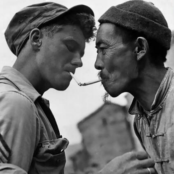 Pausing on a street in Tengchong, China, a Chinese civilian obtains a light from a U.S. Army sergeant during the liberation of the city from the Japanese military 1944