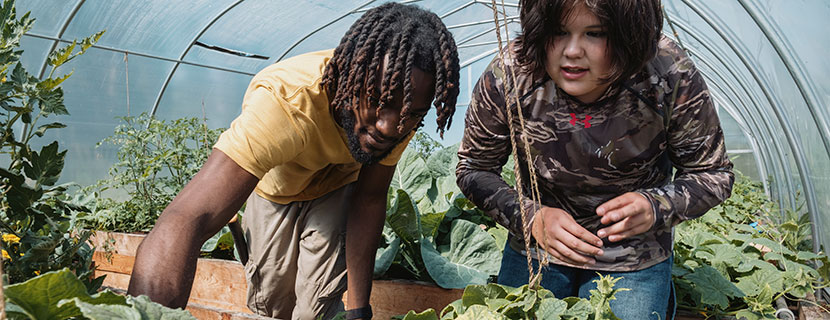 Ramon Smikle gardening with young girl