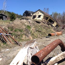 Damaged house on a hilly road.