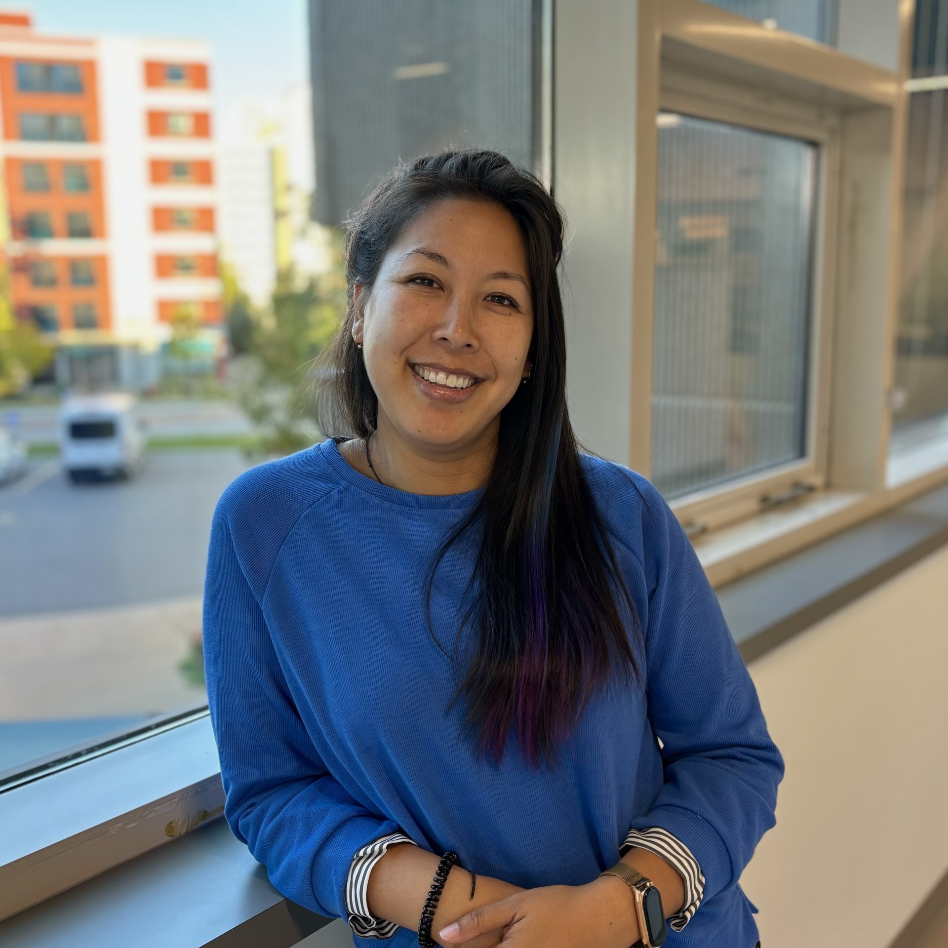 women with long dark hair smiling wearing a blue shirt