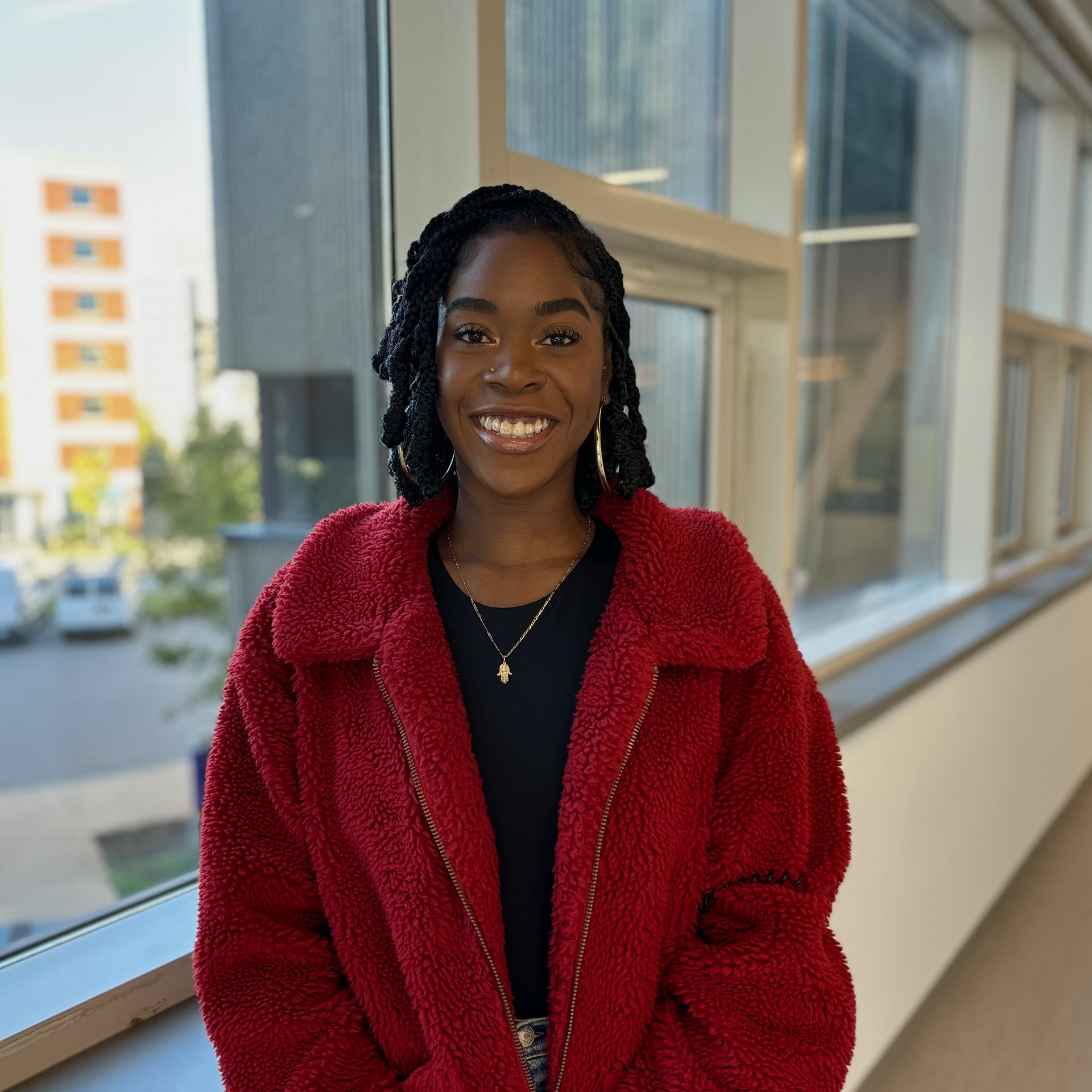 black women with short dark hair smiling in a red jacket