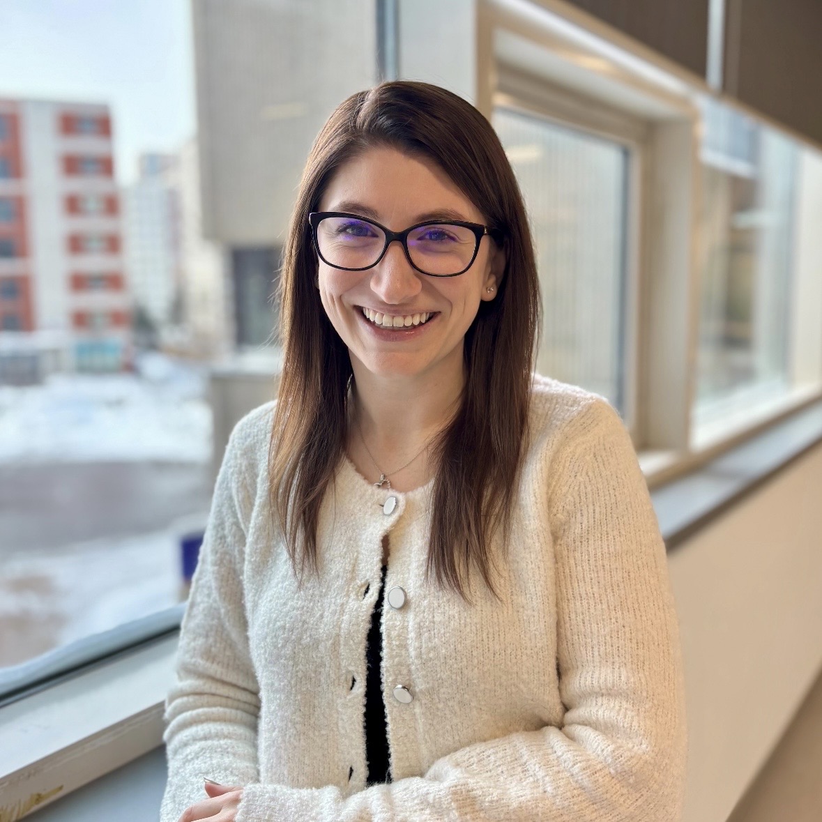 women with brown hair and glasses smiling