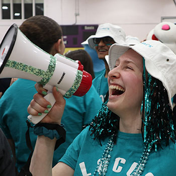 Student dressed in LOCUS gear shouting into a megaphone