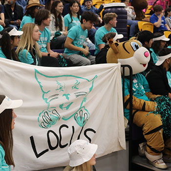 Students sitting with LOCUS lynx mascot