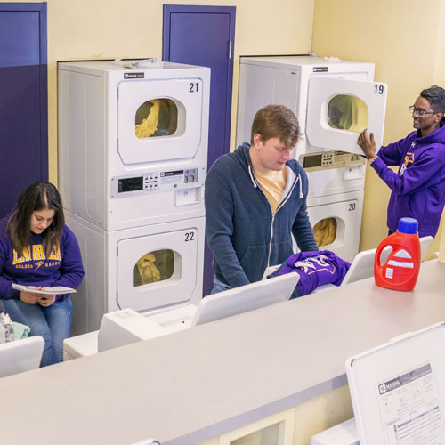 Three students doing laundry.