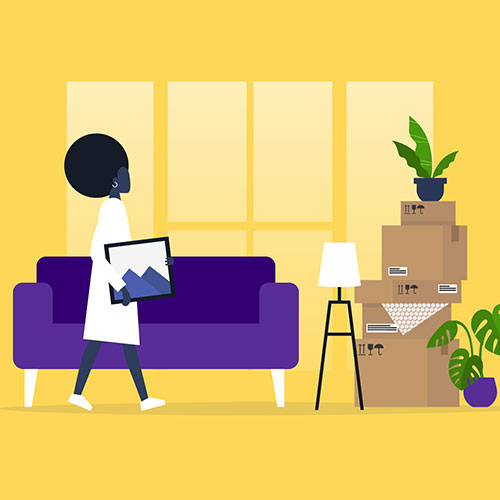 Woman holding picture frame walking towards moving boxes