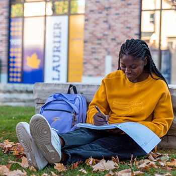 Female student reading in front of RAC building