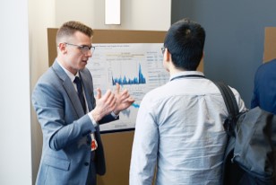 Kyle Arndt discussing his poster with an interested colleague.