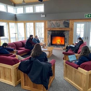 students at nature writing retreat sitting around campfire