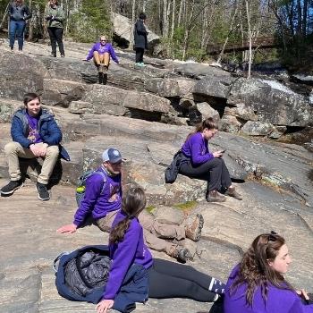 students at nature writing retreat sitting on rock