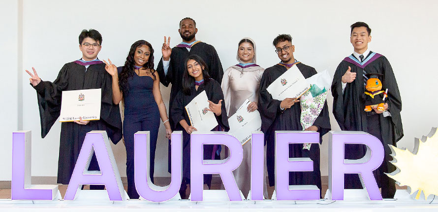 Graduates with Laurier sign