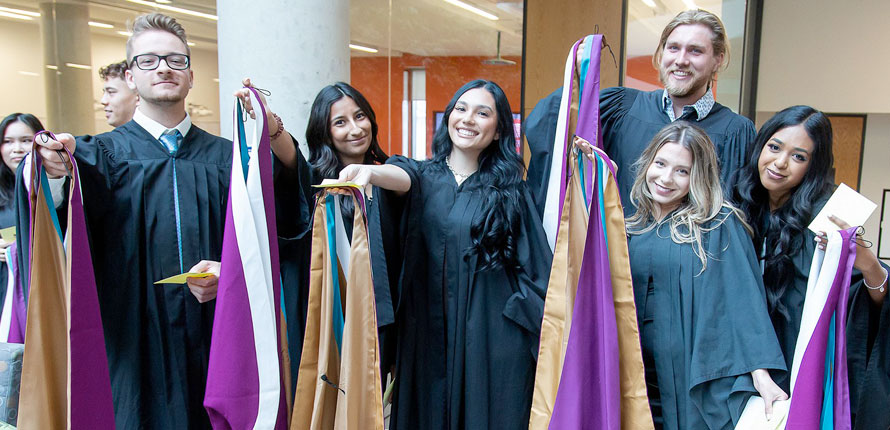Double degree graduates show off their hoods