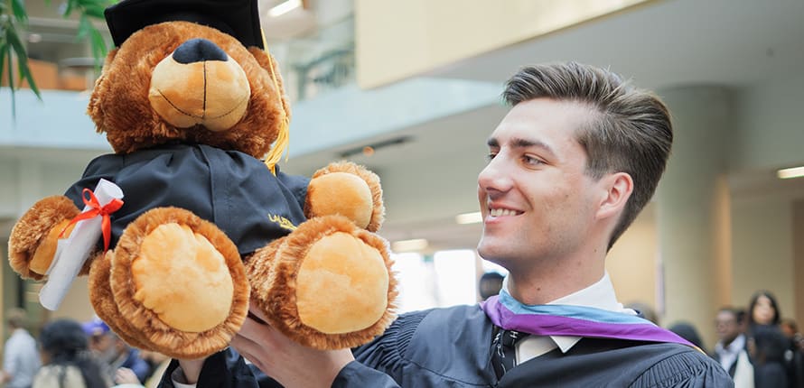 graduate holding stuffed animal grad bear