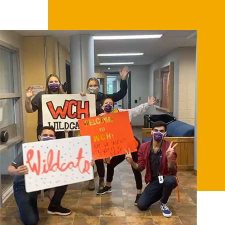 students holding signs in hallway