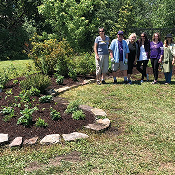 Group posing next to pollinator garden.