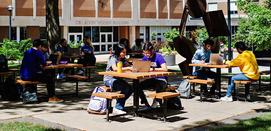 Several students sitting at tables outside of DAWB
