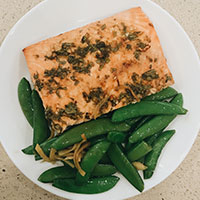 garlic lime salmon filet on a plate with roasted vegetables