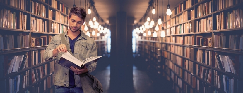 man in library looking at book