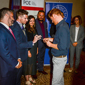 Alumnus Jeff Alpaugh hands Prince Harry a business card